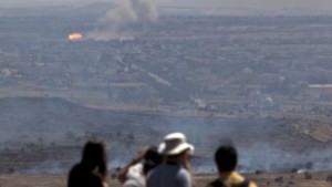 Israelis and tourists look at a fire caused by fighting in Syria from an observation point on Mt. Bental in the Golan Heights, near the border between Israel and Syria (photo credit: AP/Sebastian Scheiner)