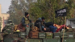 This January 2013 citizen journalism image shows rebels from al-Qaeda affiliated Jabhat al-Nusra, as they sit on a truck full of ammunition, at Taftanaz air base, that was captured by the rebels, in Idlib province, northern Syria. The photo was authenticated based on its contents and other AP reporting. (photo credit: AP Photo/Edlib News Network, ENN, File)
